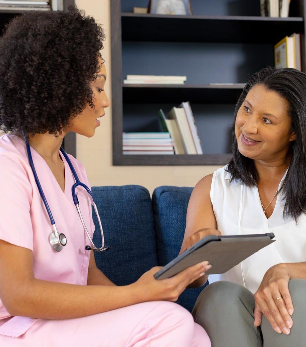 A nurse reviewing a tablet with a patient