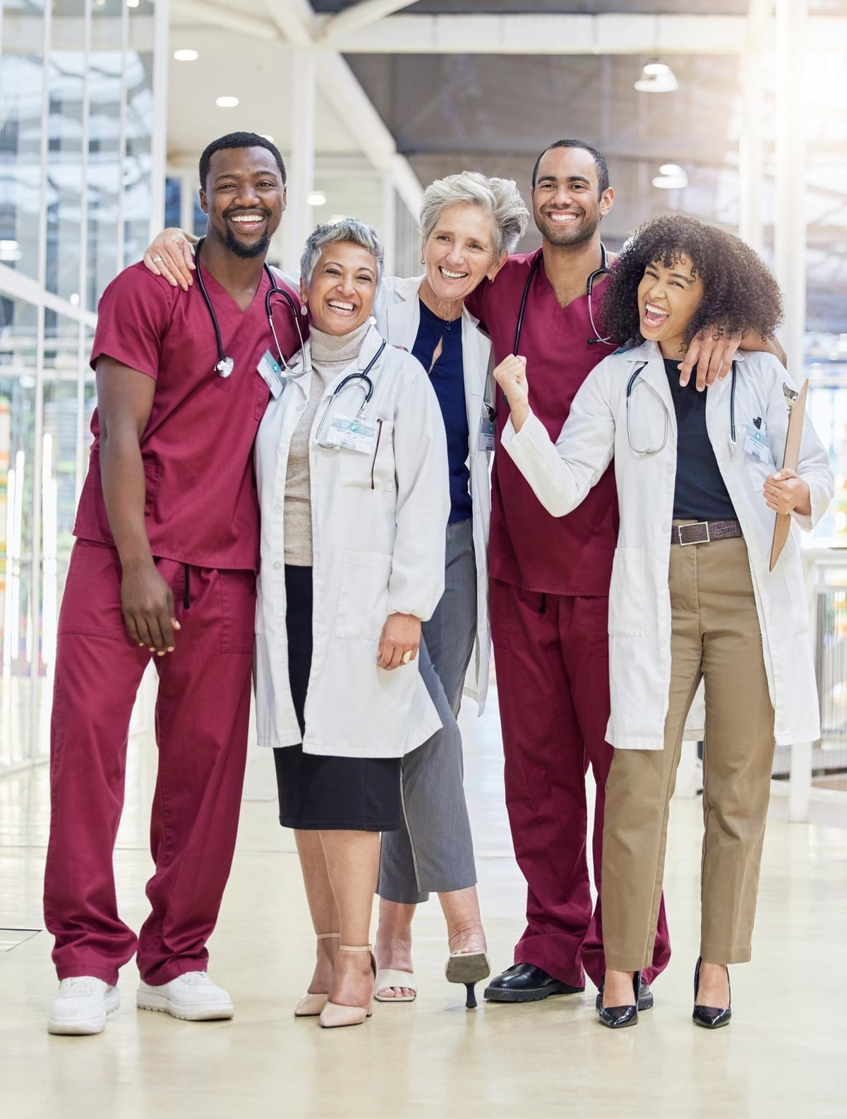 A smiling group of nurses and physicians standing together