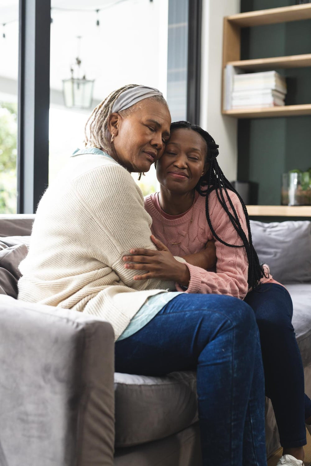 An older woman embracing her adult daughter